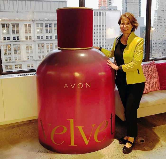 Tracey standing next to Avon perfume display